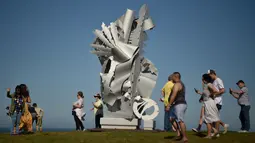 Pengunjung berjalan dekat sebuah patung bagian dari pameran Sculpture by the Sea di Sydney, Australia, Jumat (19/10). Dalam pameran ini, tak kurang dari 100 patung dengan berbagai ukuran dan bentuk menghiasi sepanjang bibir pantai. (PETER PARKS/AFP)