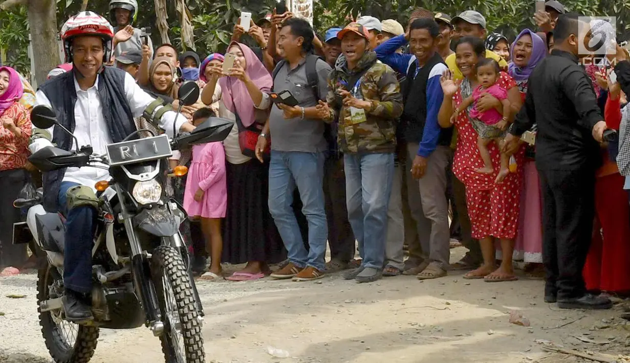 Presiden Joko Widodo mengendarai motor trail melintasi perkampungan di Muara Gembong, Bekasi (1/11). Jokowi menghadiri kegiatan Perhutanan Sosial untuk Pemerataan Ekonomi. (Liputan6.com/Biro Pers Kepresidenan/Agus Suparto)