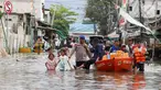 Personel kepolisian mengawal pemberian bantuan makanan siap saji kepada warga terdampak banjir rob di pemukiman padat penduduk Muara Angke, Jakarta Utara, Minggu (15/12/2024). (Liputan6.com/Herman Zakharia)