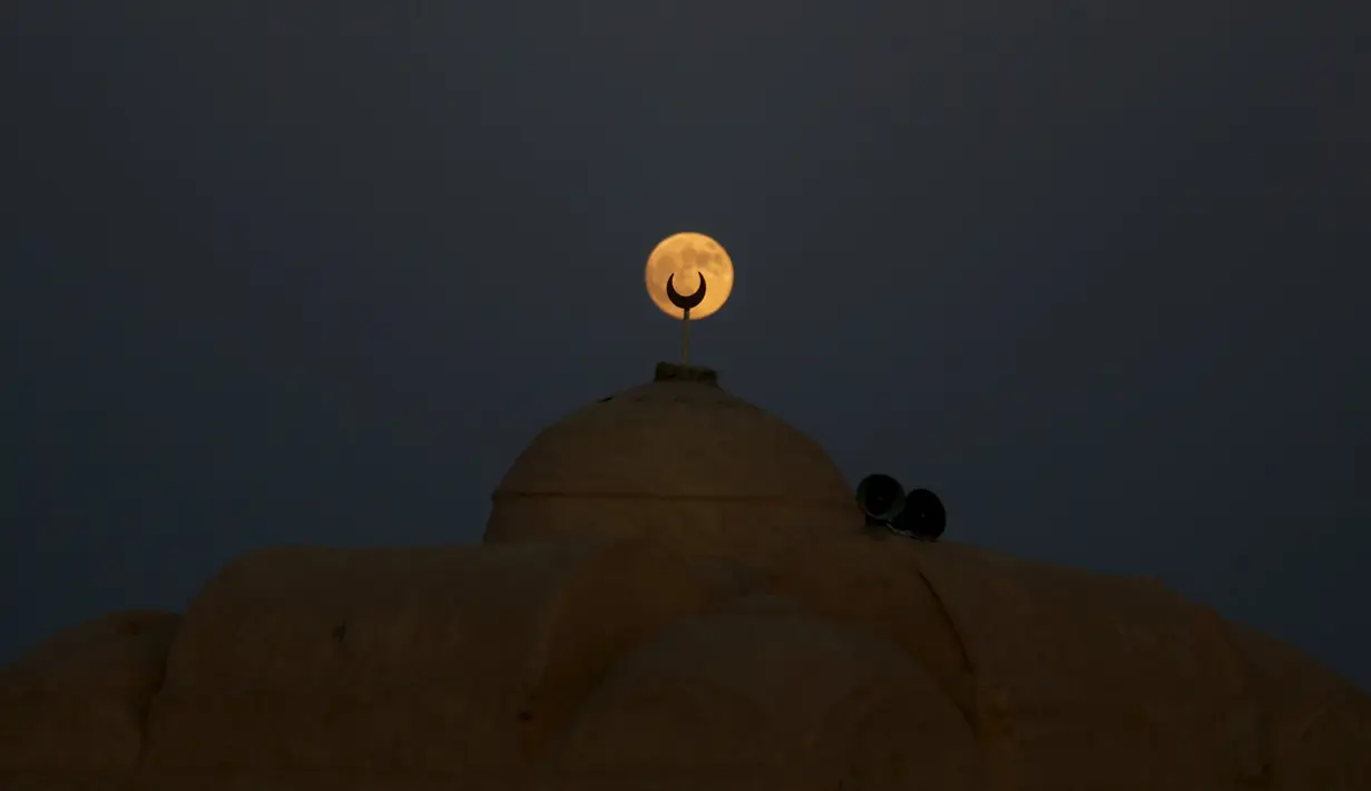 Supermoon terlihat dari balik masjid di Wadi El-Rayan Lake di gurun Al Fayoum Governorate, Mesir, Minggu (27/9). Gerhana Bulan Supermoon (Bulan merah darah) kembali menampakkan keindahannya setelah 18 tahun tidak terjadi. (REUTERS/Amr Abdallah Dalsh)