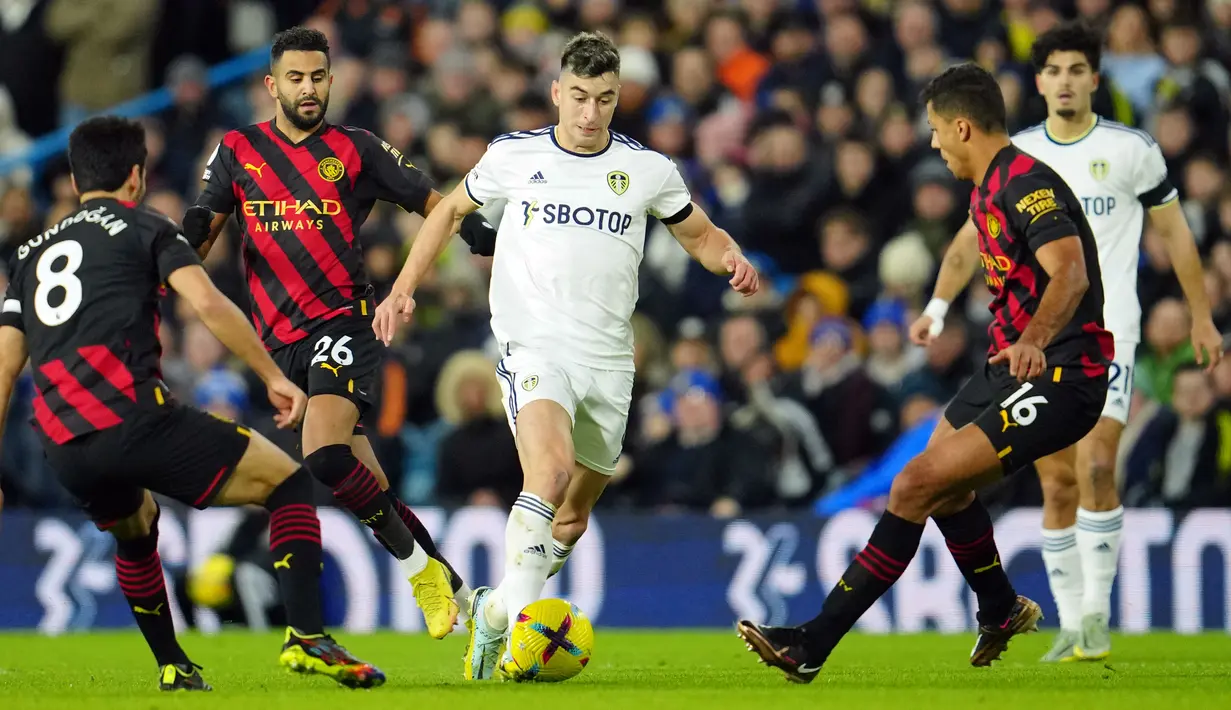 Pemain Leeds United Marc Roca (tengah) menggiring bola melewati pemain Manchester City Rodrigo (kanan) dan Ilkay Gundogan (kiri) pada pertandingan sepak bola Liga Inggris di Stadion Elland Road, Leeds, Inggris, 28 Desember 2022. Manchester City mengalahkan Leeds United dengan skor 3-1. (AP Photo/Jon Super)