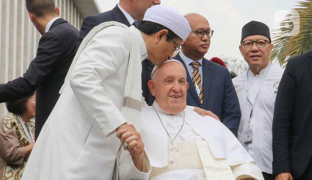 Imam Besar Masjid Istiqlal Nasaruddin Umar (kiri) mencium Pemimpin Takhta Suci Vatikan Paus Fransiskus usai melakukan foto bersama di Masjid Istiqlal, Jakarta, Kamis (5/9/2024). (Liputan6.com/Herman Zakharia)
