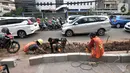 Aktivitas pekerja saat menyelesaikan proyek revitalisasi trotoar di Jalan Tebet Raya, Jakarta, Selasa (5/11/2019). Adanya proyek revitalisasi trotoar di sepanjang Jalan Tebet Raya mengakibatkan kemacetan di kawasan tersebut semakin parah, terlebih saat jam sibuk. (merdeka.com/Iqbal Nugroho)
