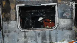 Petugas memeriksa kondisi dari gerbong kereta api yang terbakar usai terjadi tabrakan dengan mobil di perlintasan Kramat, Senen, Jakarta, Selasa (13/6). Belum ada kabar korban jiwa dalam peristiwa tersebut. (Liputan6.com/Helmi Afandi)