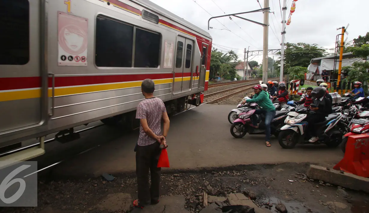 Sebuah kereta Commuter Line melintas di perlintasan kereta api Bintaro, Jakarta, Senin (16/1). Untuk mengurangi angka kecelakaan di perlintasan kereta api, Pemerintah Provinsi DKI Jakarta akan membangun jalan layang. (Liputan6.com/Gempur M. Surya)