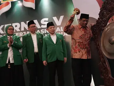 Menko Polhukam Mahfud Md didampingi Plt Ketua Umum PPP Suharso Monoarfa memukul gong untuk membuka Musyawarah Kerja Nasional (Mukernas) ke V PPP di Jakarta, Sabtu (14/12/2019). Salah satu agenda yang akan dibahas dalam acara ini adalah pelaksanaan Muktamar PPP. (Liputan6.com/Angga Yuniar)