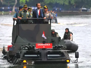 Presiden Joko Widodo berada diatas Panser Anoa Amfibi didampingi Panglima TNI, Gatot Nurmantyo di Mabes TNI, Cilangkap, Senin (16/1). Kedatangan Presiden RI di Mabes TNI di sambut dengan jajar Kehormatan di Pintu Utama. (Liputan6.com/Angga Yuniar)