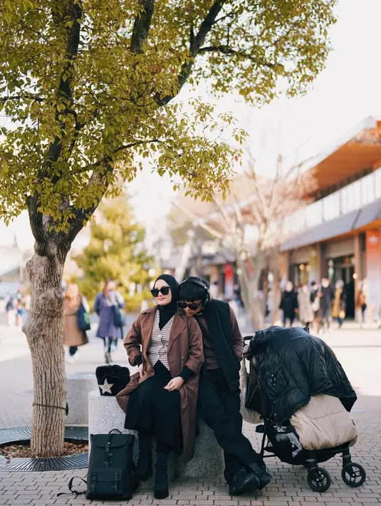 Tampil chic dengan layering outfit, Dinda Hauw memadukan inner hitam dengan vest dan long coat. @rey_mbayang.