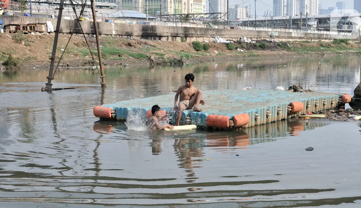 Anak-anak berenang di Kanal Banjir Barat, Jakarta, Minggu (3/11/2019). Banyaknya sampah yang menggenang tidak menghentikan keseruan anak-anak berenang di Kanal Banjir Barat. (merdeka.com/Iqbal Nugroho)