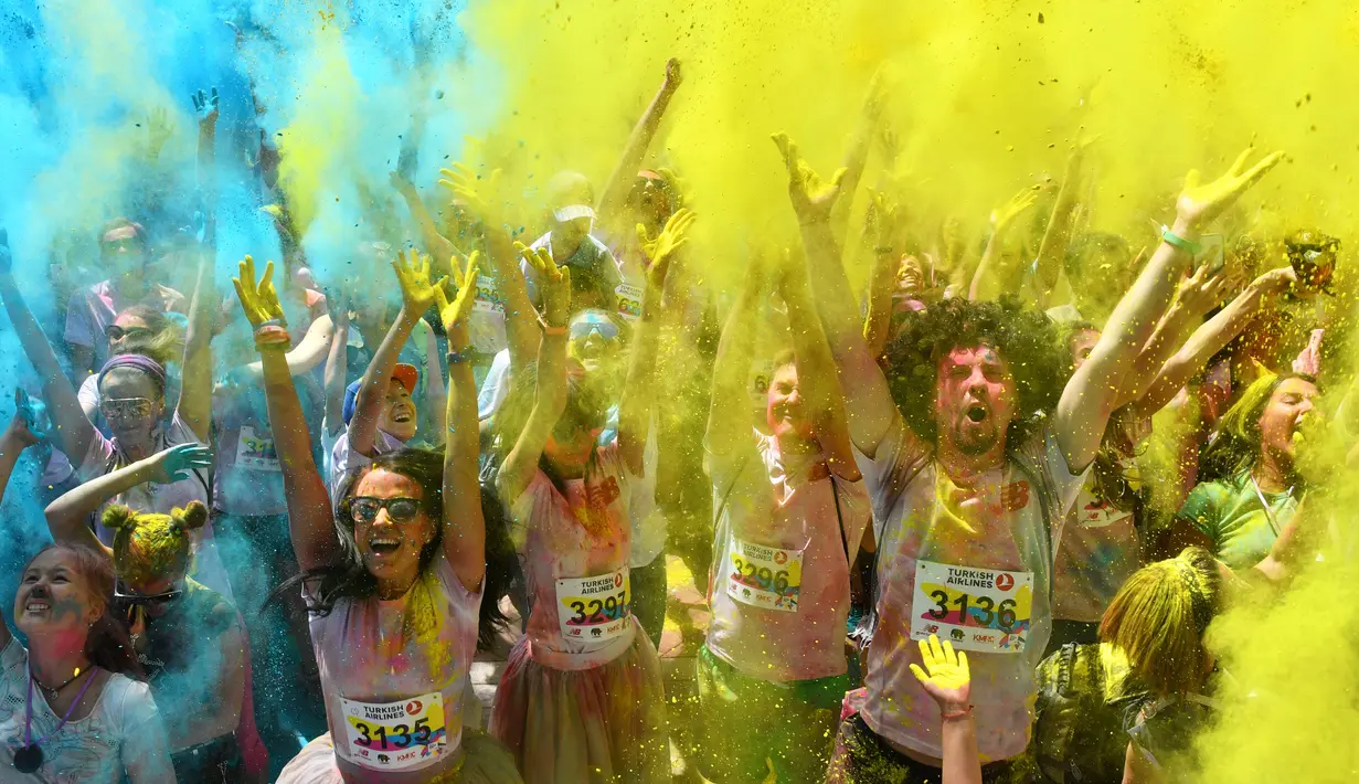 Peserta lomba bergembira saat disiram bubuk warna-warni saat mengikuti Kyiv Color Run di Kiev, Ukraina, Minggu (10/6). The Color Run diluncurkan dan diselenggarakan pertama kali pada Januari 2012 di Amerika Serikat. (AFP PHOTO/Sergei SUPINSKY)