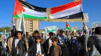 Warga Yaman meneriakkan slogan-slogan dan mengibarkan bendera Palestina selama pawai solidaritas dengan rakyat Gaza pada 24 November 2023, di ibu kota Sanaa yang dikuasai Houthi. (MOHAMMED HUWAIS/AFP)