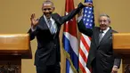 Presiden Kuba Raul Castro mengangkat tangan Presiden AS Barack Obama usai konferensi pers di Istana Revolusi, Havana, Senin (21/3). Obama menjadi presiden pertama AS yang berkunjung ke negara komunis itu sejak 88 tahun terakhir. (REUTERS/Carlos Barria)