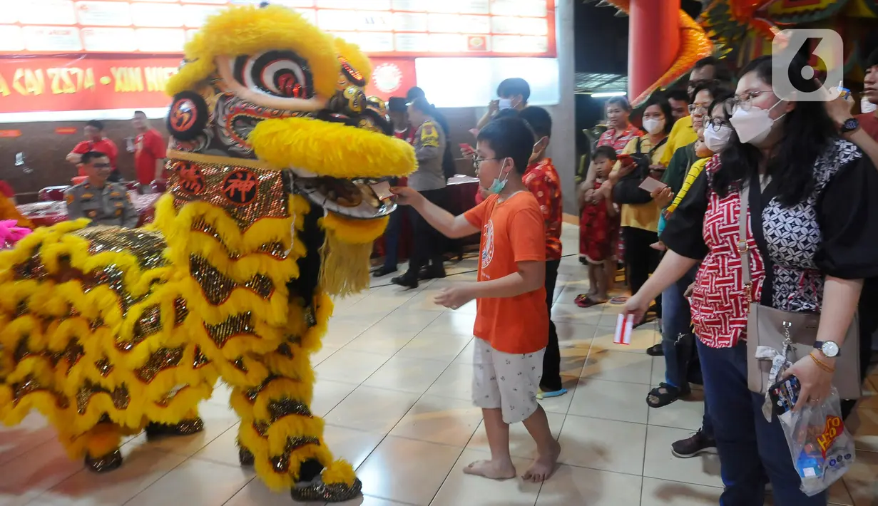 Warga memberikan angpao kepada barongsai saat perayaan malam Tahun Baru Imlek 2574 di Vihara Kwan In Thang, Pondok Cabe, Tangerang Selatan, Banten, Sabtu (21/1/2023). Perayaan Imlek berlangsung semarak dengan adanya pertunjukan barongsai setelah sempat vakum selama 2 tahun akibat pandemi Covid-19. (merdeka.com/Arie Basuki)