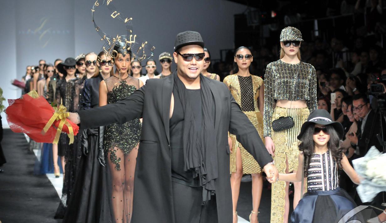 Ivan Gunawan tampil bersama seorang gadis cilik di akhir fashion show untuk menerima karangan bunga. Foto diambil pada Rabu (5/11/2014) (Liputan6.com/Panji Diksana)