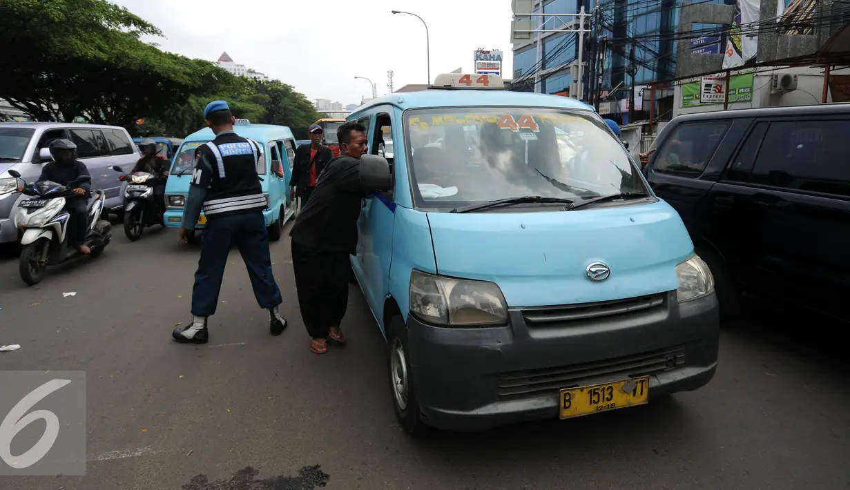 Pengemudi mikrolet M 44 memindahkan kendaraanya usai melakukan aksi menutupi persimpangan jalan layang KH Abdulah Syafei, Jakarta, Rabu (25/5). Aksiini sempat membuat kemacetan panjang menuju Kampung Melayu. (Liputan6.com/Helmi Fithriansyah)