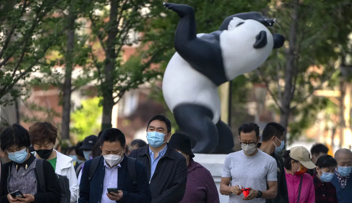 <p>Orang-orang mengantre untuk tes COVID-19 pada tempat pengujian setelah pihak berwenang memerintahkan putaran ketiga dari tiga tes COVID-19 berturut-turut untuk penduduk di Distrik Chaoyang, Beijing, China, Sabtu (7/5/2022). (AP Photo/Mark Schiefelbein)</p>