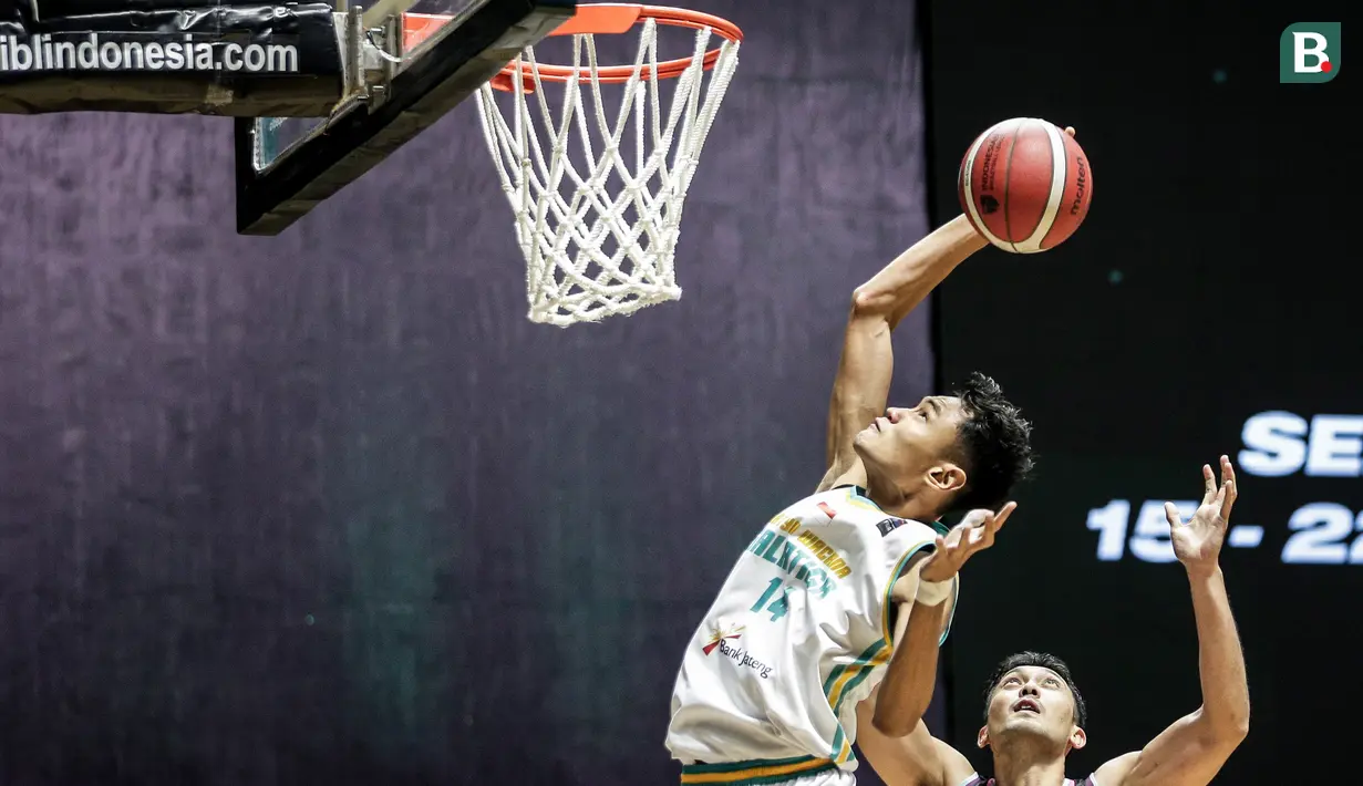 Pemain Satya Wacana Salatiga, Randy Ady Prasetya (kiri) berusaha memasukkan bola saat laga lanjutan Seri 1 IBL 2022 melawan Bali United Basketball di Hall Basket GBK, Senayan, Kamis (20/01/2022). (Bola.com/Bagaskara Lazuardi)