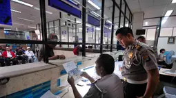 Petugas memberi penjelasan pada wajib pajak di Samsat Jakarta Pusat, Kamis (11/12/2014). (Liputan6.com/Johan Tallo)