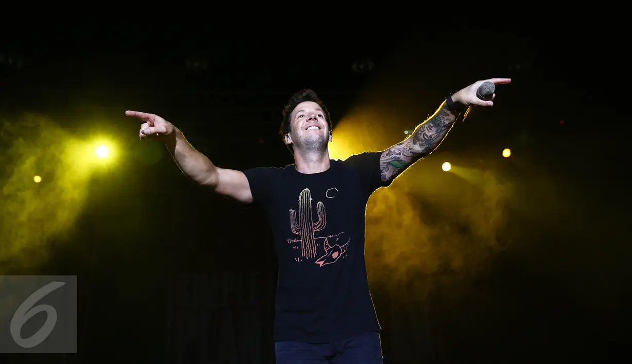 Vokalis Simple Plan, Pierre Bouvier mengajak penonton ikut bernyanyi dalam konser di Ecovention Eco Park, Ancol, Jakarta, Minggu (4/9). Konser bertajuk Taking One for The Team Tour ini merupakan promosi album terbaru tersebut. (Liputan6.com/Faizal Fanani)