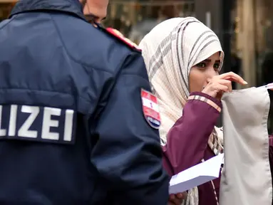 Seorang wanita Muslim dipaksa oleh polisi Austria melepaskan cadarnya saat berada di tempat umum di kota Zell am See, Minggu (1/10). Yang dilakukan polisi itu merupakan bagian dari penerapan aturan baru di negara tersebut. (BARBARA GINDL/APA/AFP)