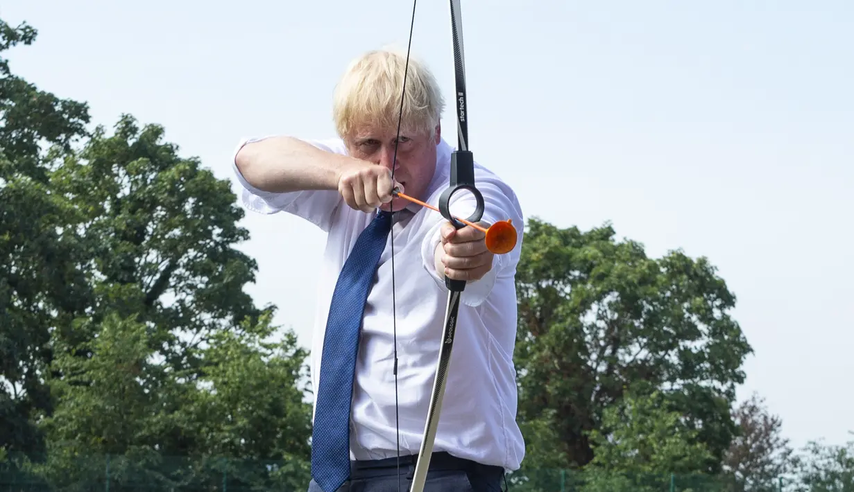 PM Inggris Boris Johnson bermain panahan saat mengunjungi Premier Education Summer Camp di Sacred Heart of Mary Girl's School, Upminster, Inggris, Senin (10/8/2020). Kunjungan Boris untuk melihat persiapan jelang pembukaan kembali sekolah pada September mendatang. (Lucy Young/Pool via AP)