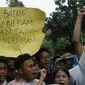 Puluhan pemuda kampung Luar Batang mengangkat tulisan saat melakukan aksi di depan Balai Kota Jakarta, Jumat (22/4/2016). Mereka mempertanyakan kebijakan Pemprov DKI Jakarta yang melakukan penggusuran. (Liputan6.com/Helmi Fithriansyah)