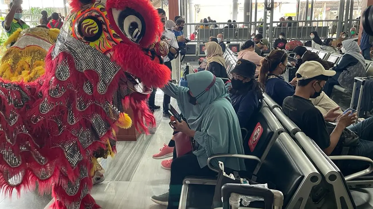 Atraksi barongsai menyapa penumpang kereta di Stasiun Gubeng Surabaya. (Dian Kurniawan/Liputan6.com)