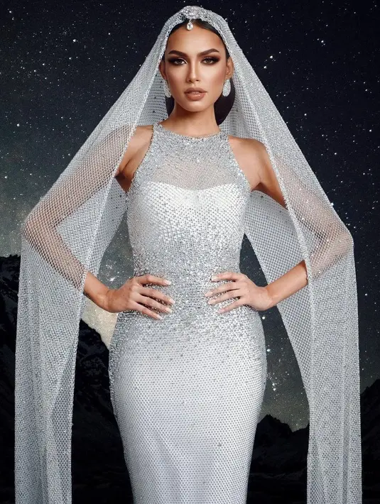 Gaun tanpa lengan tersebut dilengkapi penutup kepala sepanjang gaunnya. Memiliki detail jaring-jaring dan bertabur beads.  [@ericarobin_official]