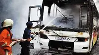 Petugas Pemadam Kebakaran berusaha memadamkan api yang membakar Bus Biang Lala di Jalan MH. Thamrin, Jakarta, Jumat (10/12). (Antara)