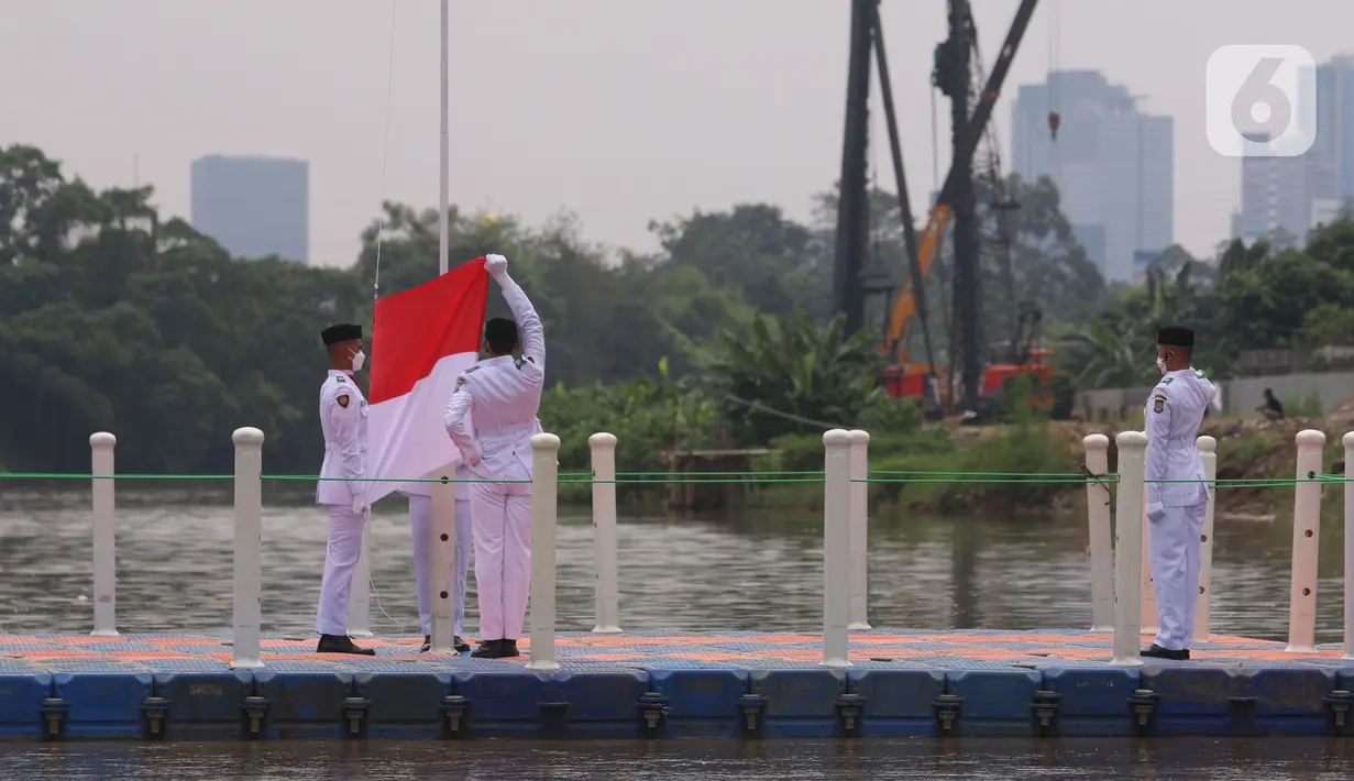 Anggota Paskibraka melakukan pengibaran bendera merah putih di Sungai Cisadane, Kota Tangerang, Banten, Kamis (28/10/2021). Pengibaran bendera merah putih yang di ikuti puluhan pemuda tersebut di lakukan untuk memperingati hari sumpah pemuda. (Liputan6.com/Angga Yuniar)