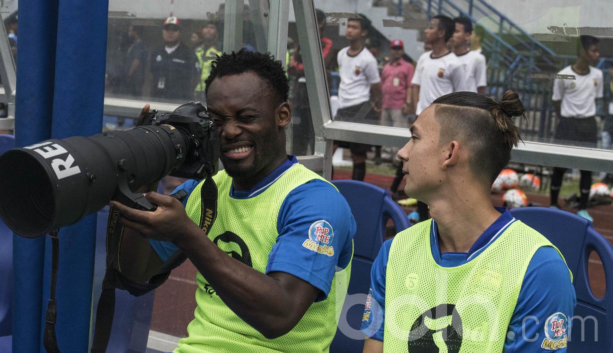 Gelandang Persib Bandung, Michael Essien, mencoba menggunakan kamera milik wartawan sebelum laga uji coba melawan Bali United di Stadion GBLA Bandung, Jawa Barat, Sabtu (8/4/2017). (Bola.com/Vitalis Yogi Trisna)