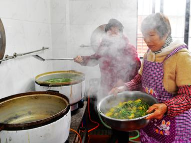 Sukarelawan memasak di sebuah kantin untuk warga lanjut usia (lansia) di Desa Yingshan, Kota Quanzhou, Provinsi Fujian, China pada 17 Desember 2020. Banyak desa dan komunitas di Quanzhou mendirikan kantin makanan gratis untuk warga berusia 60 tahun ke atas yang tinggal sendiri. (Xinhua/Wei Peiquan)