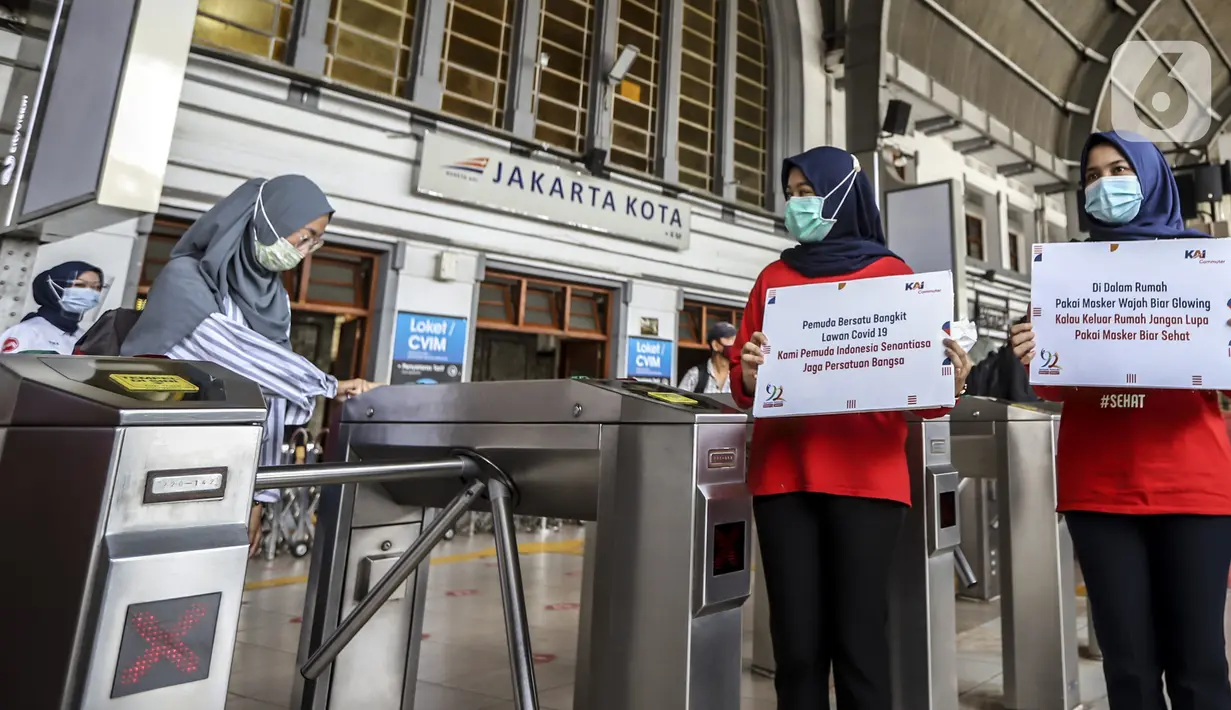 Petugas menunjukkan pesan peringatan COVID-19 di Stasiun Jakarta Kota, Jakarta, Rabu (28/10/2020). Mengantisipasi lonjakan penumpang saat cuti bersama dan Sumpah Pemuda, PT KCI mengajak pengguna KRL bersatu dan bangkit melawan COVID-19 dengan menerapkan 3M. (Liputan6.com/Johan Tallo)