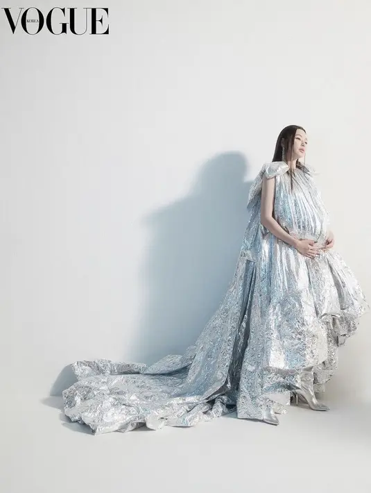 <p>Ia pun tampil anggun dengan gaun silver yang menjutai lengkap dengan heels tertutup warna serupa.&nbsp;@voguekorea/Jungwook Mok</p>