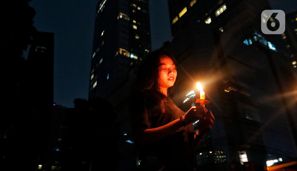 Karyawan menyalakan lilin di kawasan SCBD, Jakarta, Sabtu (25/3/2023). (Liputan6.com/Angga Yuniar)