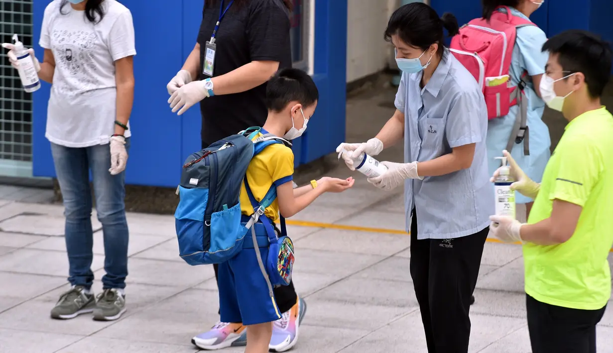 Seorang murid mendisinfeksi tangannya sebelum memasuki sekolah di Tsuen Wan, Hong Kong, China selatan, pada 29 September 2020. Aturan menjaga jarak sosial (social distancing) sebagian telah dilonggarkan dan kehidupan masyarakat mulai kembali normal. (Xinhua/Lo Ping Fai)