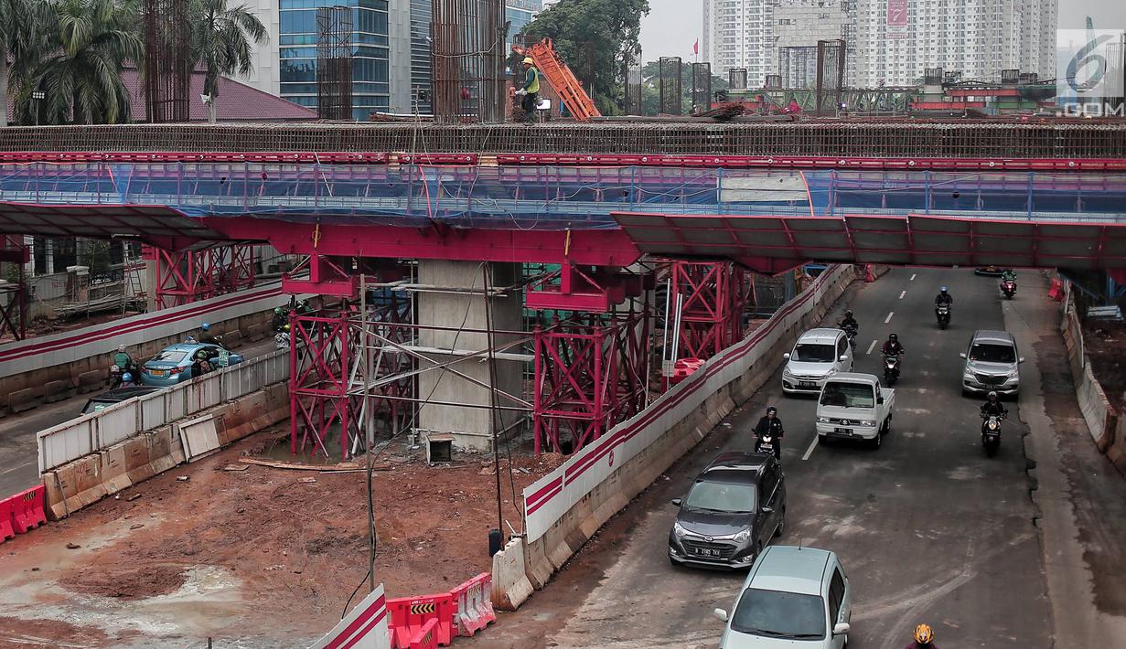 Kendaraan melintas di bawah pembangunan proyek Light Rail Transit (LRT) Jabodebek fase I di kawasan Cawang, Jakarta, Senin (14/1). Progres konstruksi stasiun LRT Cawang, Jakarta Timur sudah mencapai 62,2 persen. (Liputan6.com/Faizal Fanani)