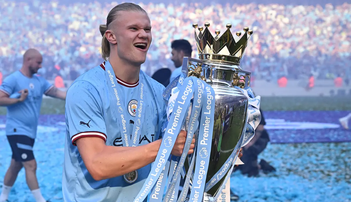 Striker Manchester City, Erling Haaland berpose dengan trofi Liga Inggris 2022/2023 dalam perayaan gelar setelah laga menghadapi Chelsea di Etihad Stadium, Manchester (21/5/2023). Erling Haaland menjadi pemain terbaru Norwegia yang mampu meraih gelar Liga Inggris. Ia melakukannya di musim pertama bersama Manchester City yang baru mendatangkannya pada awal musim 2022/2023 dari Borussia Dortmund. (AFP/Oli Scarff)