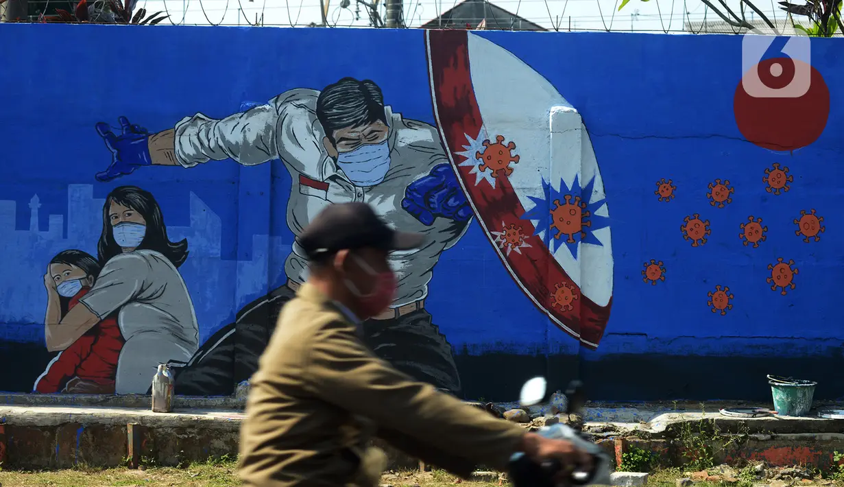 Pengendara sepeda motor lewat depan mural bertemakan COVID-19 di kawasan Manggarai, Bukit Duri, Jakarta, Jumat (28/8/2020). Mural tersebut dibuat untuk meningkatkan kepatuhan masyarakat akan protokol kesehatan karena kasus COVID-19 nasional terus meningkat. (merdeka.com/Imam Buhori)