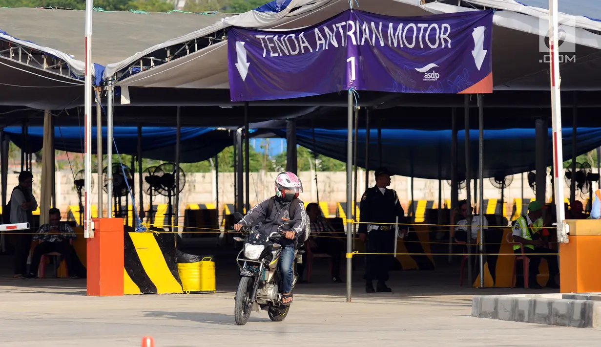 Pemudik melintasi lokasi antrian motor di dermaga 6 Pelabuhan Penyebrangan Merak-Bakauheni, Banten, Rabu (21/6). Hingga H-4 lebaran 2017, belum terlihat penumpukan penumpang baik di dermaga penumpang maupun kendaraan. (Liputan6.com/Helmi Fithriansyah)