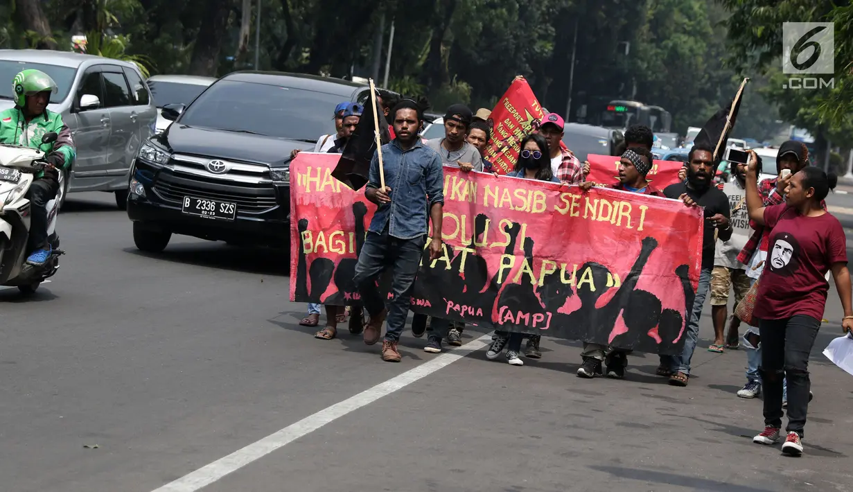 Sejumlah pemuda Papua berjalan kaki menuju kawasan depan Istana Negara, Jakarta, Kamis (2/8). Aksi ini untuk memperingati 49 tahun penentuan pendapat rakyat (Pepera) 1969. (Liputan6.com/Helmi Fithriansyah)