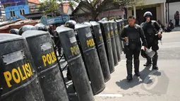 Puluhan anggota Brimob Polda Jatim membuat barikade penutup jalan Embong Malang, Surabaya, Jawa Timur, Sabtu (18/4/2015). Jalan Embong Malang, Surabaya ditutup total selama aksi unjuk rasa para supporter Persebaya 1927. (Liputan6.com/Helmi Fithriansyah)