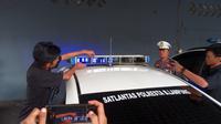 Pemasangan kaca film pada lampu rotator mobil Satlantas Polresta Bandar Lampung. Foto : (Liputan6.com/Ardi)