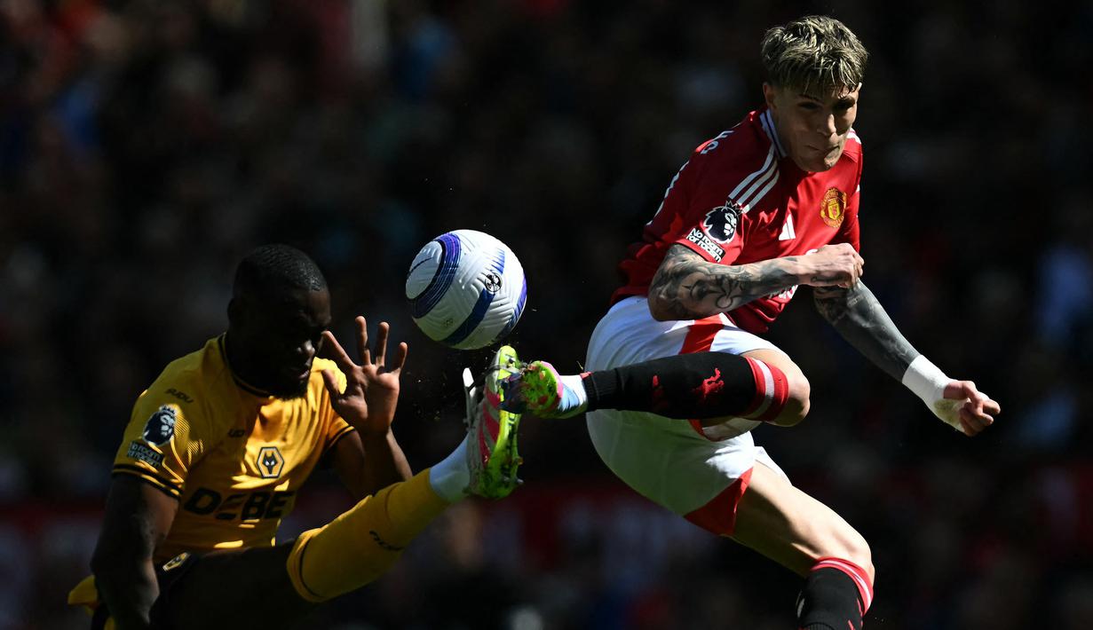 Pemain Manchester United, Alejandro Garnacho (kanan) berebut bola melawan pemain Wolves, Tote Gomes dalam laga lanjutan Liga Inggris 2024/2025 di Old Trafford, Inggris, Minggu (20/04/2025) waktu setempat. (AFP/Paul Ellis)