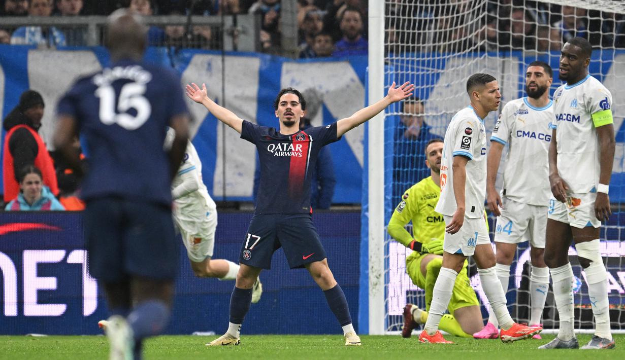 Pemain Paris Saint-Germain, Vitinha, melakukan selebrasi setelah mencetak gol ke gawang Marseille dalam duel pekan ke-27 Ligue 1 2023/2024 di Stade Velodrome, Senin (1/4/2024). Tambahan tiga poin ini memperkuat posisi PSG di puncak klasemen sementara Liga Prancis 2023/2024. (AFP/Nicolas Tucat)