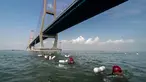 Prajurit Korps Marinir TNI AL berenang melintas selat Madura dari Surabaya sepanjang 5,4 km, Kamis (28/4). Renang yang mengambil start di Jembatan Suramadu dan finish di Bangkalan Madura ini untuk memperingati HUT Pasmar 1 ke-15. (Juni KRISWANTO/AFP)