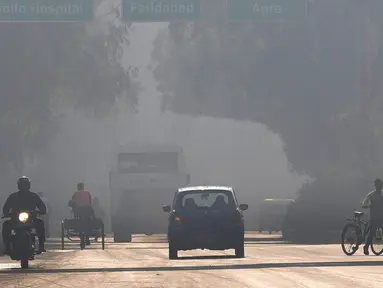 Seorang pengendara sepeda motor mengemudi di sisi jalan yang salah di tengah kabut pagi dan kabut asap beracun di New Delhi, India, 17 November 2021. India menutup sementara lima pembangkit listrik bertenaga batu bara di New Delhi akibat polusi udara sejak pekan lalu. (AP Photo/Manish Swarup)