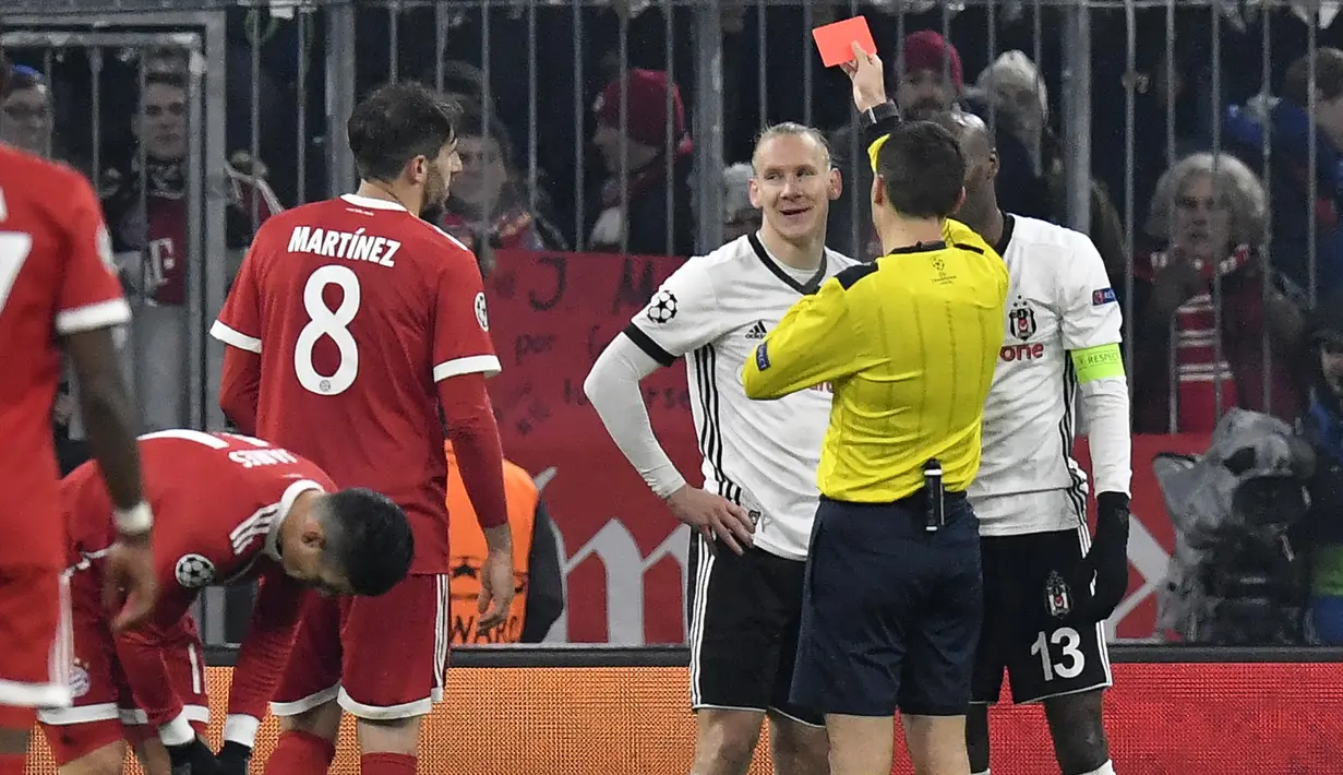 Wasit memberikan kartu merah kepada bek Besiktas, Domagoj Vida, saat melawan Bayern Munchen pada laga Liga Champions di Stadion Allianz Arena, Munchen, Selasa (20/2/2018). Munchen menang 5-0 atas Besiktas. (AFP/Thomas Kienzle)