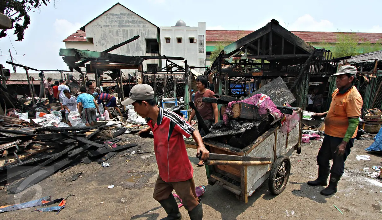Warga mengumpulkan puing sisa kebakaran di Pasar  Inpres Tanah Abang, Jakarta, Minggu (11/10/2015). Kebakaran yang terjadi pada Minggu (11/10) dini hari tersebut menghanguskan 136 kios (Liputan6.com/Immanuel Antonius)