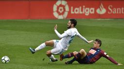 Gelandang Real Madrid, Isco, terjatuh saat berebut bola dengan gelandang Eibar, Dani Garcia, pada laga La Liga di Stadion Ipurua, Sabtu (10/3/2018). Eibar takluk 1-2 dari Real Madrid. (AP/Alvaro Barrientos)